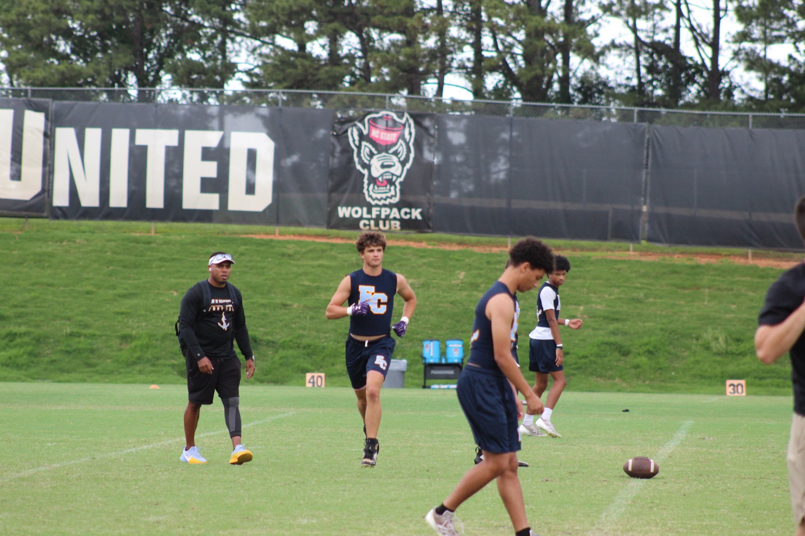 Conlan Elson at NC State 7v7 camp, Wolfpack Club banner